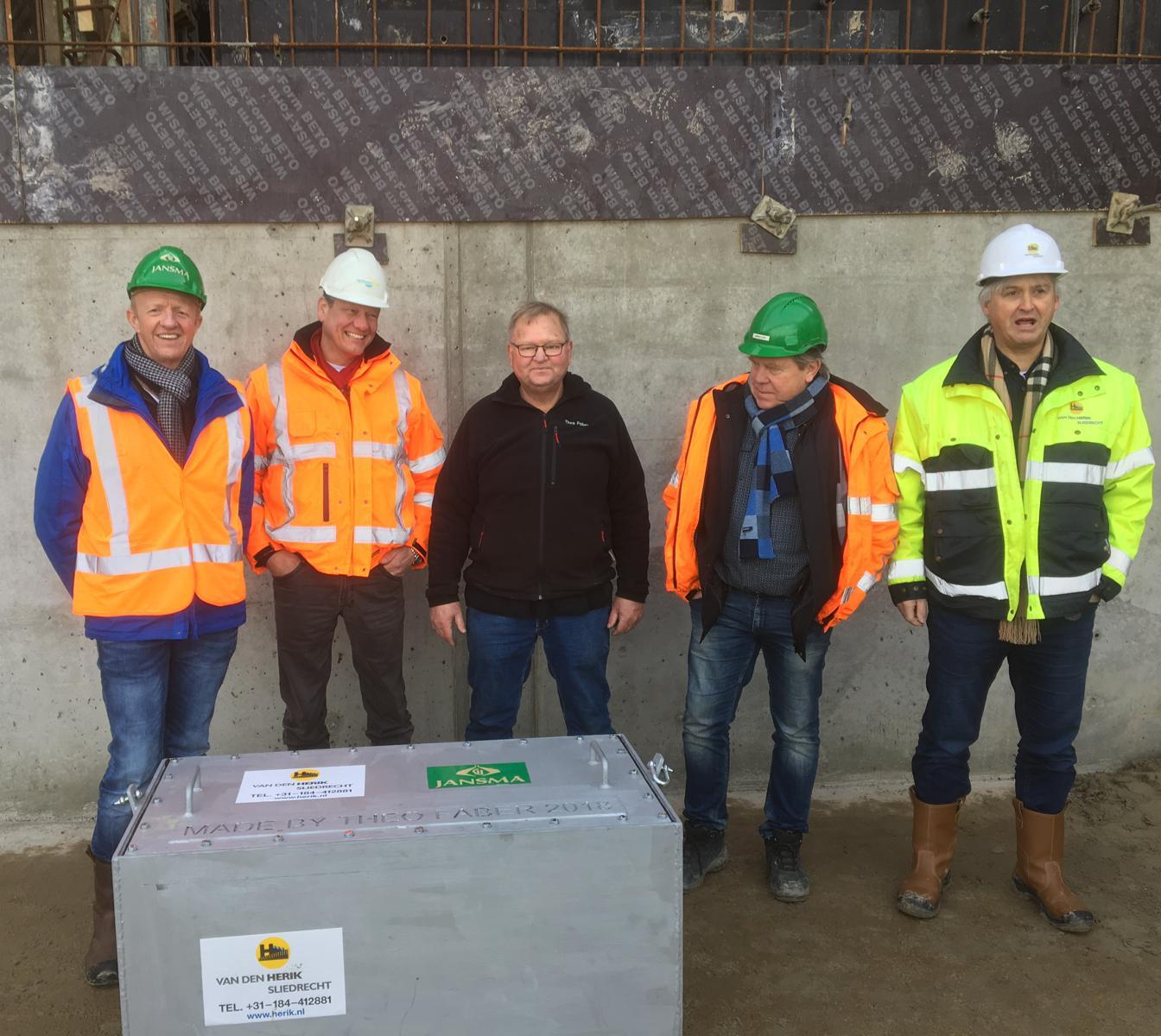 Jan Huijbers (rechts) en Richard den Haan (2e van links) bij het plaatsen van een tijdcapsule op de duiker op Ameland.